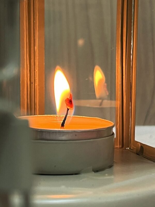 Lit scented candle adding warm fall ambience to a small apartment