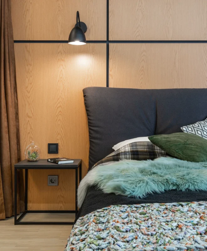 Bed with plush cushions pushed against a wall to save floor space