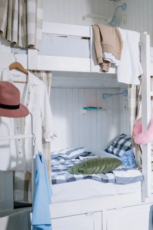 Dorm style bunk bed with hanging privacy curtains and colorful decor