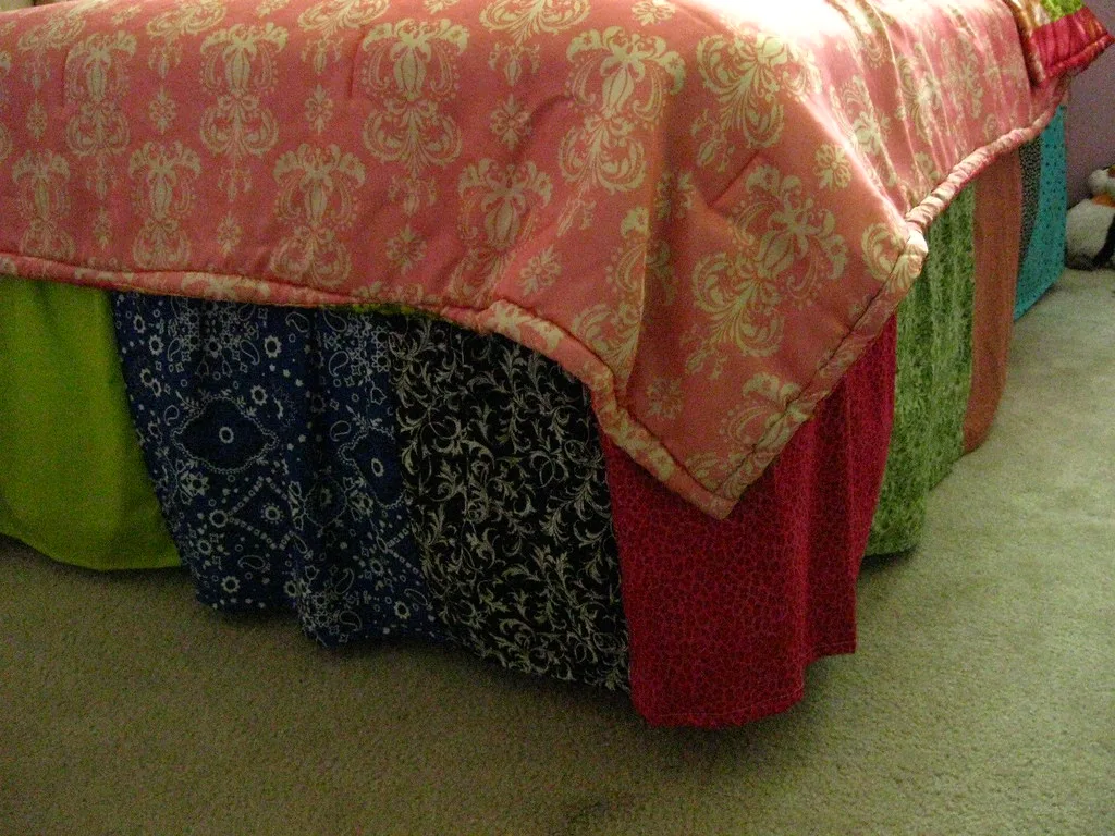 Bed with patchwork bed skirt hiding under-bed storage