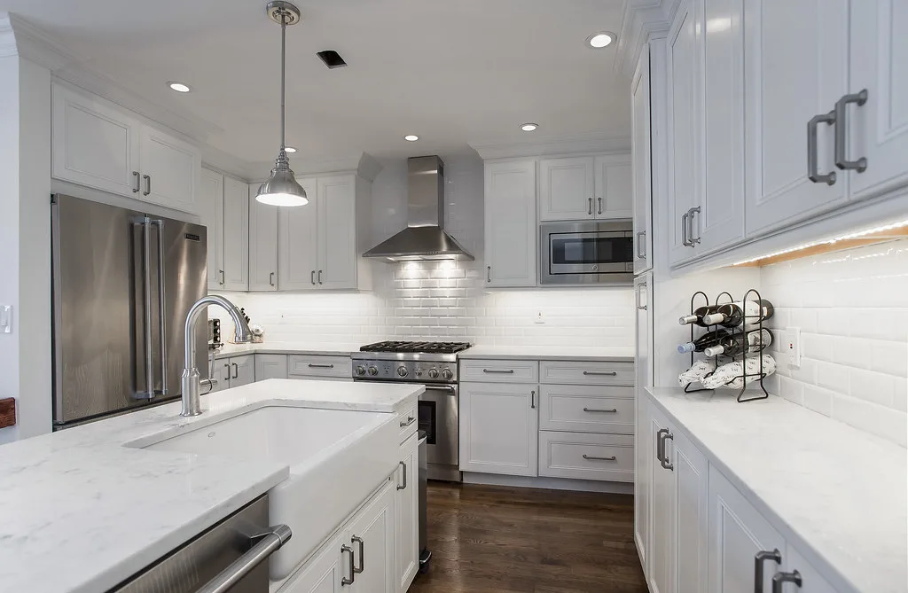 White kitchen with under-cabinet lighting glowing
