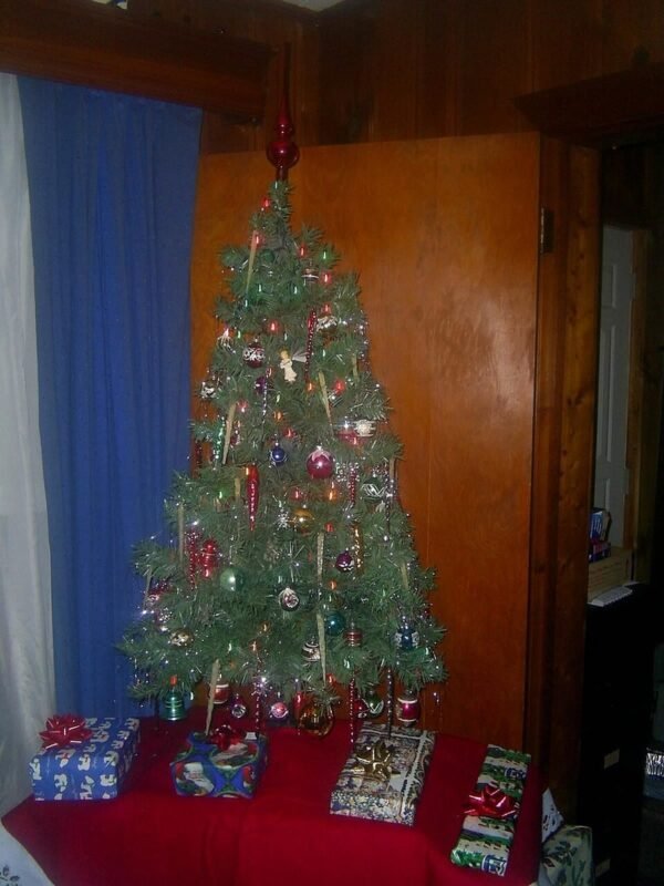 Small artificial Christmas tree with presents for small space Christmas decor