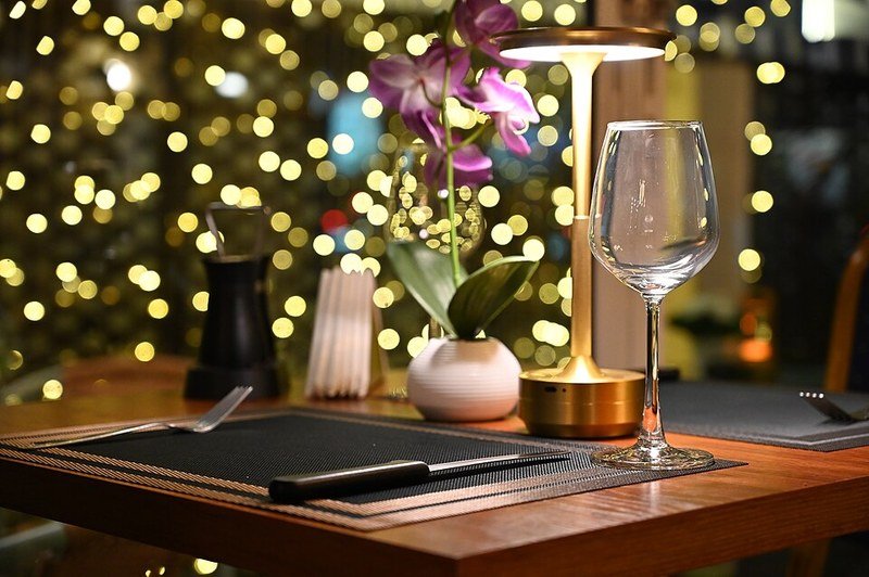 Warm Christmas fairy lights glowing behind a candlelit table setting
