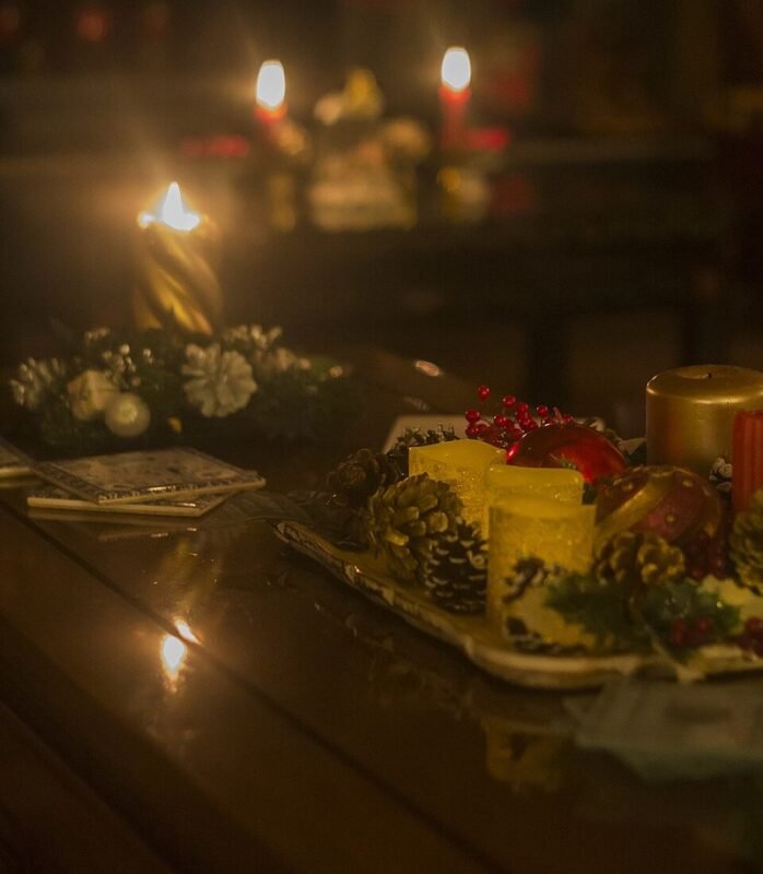 Candlelit Christmas table centerpiece with pinecones and red berries