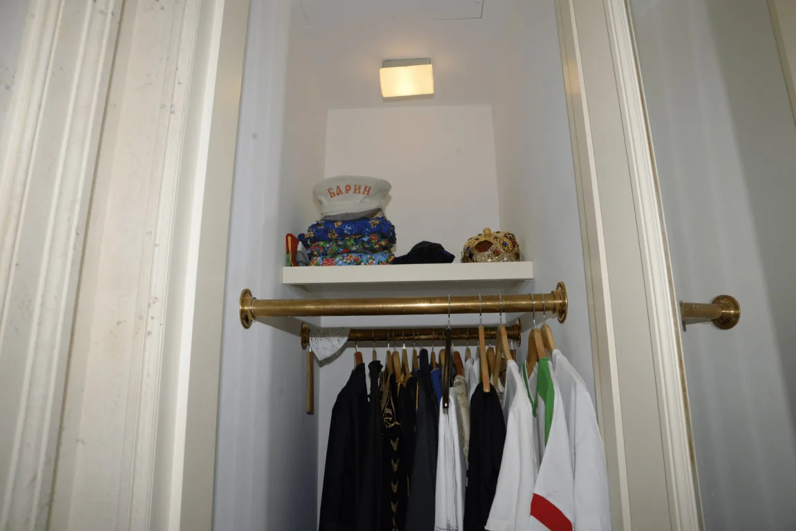 Neatly organized small closet with double hanging rods and hats above