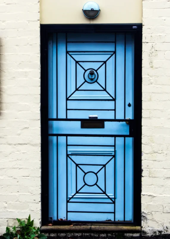 Blue painted front door marking the entry of a small home