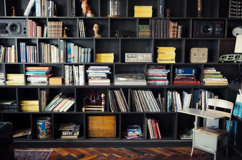 Tall black cube bookshelf used as a room divider in a small living room