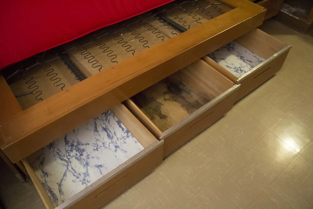 Pull-out storage drawers under a dorm bed in student housing