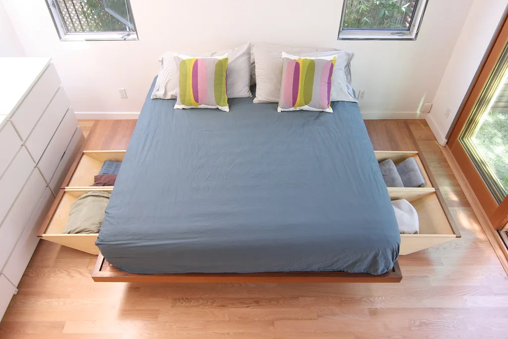 Bed with pull-out drawers underneath holding folded clothes