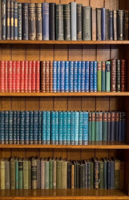 Refinished wooden bookshelf filled with books, thrift store bookcase flip before and after
