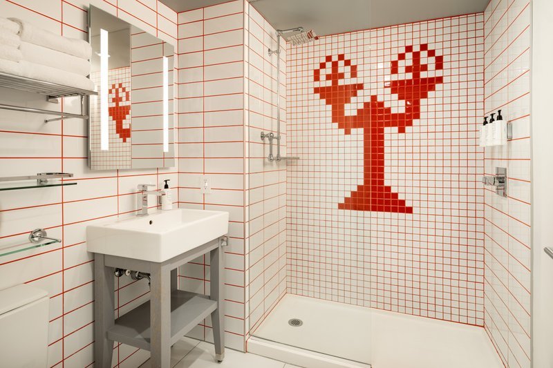 Small bathroom with open-leg vanity, large mirror and walk-in shower