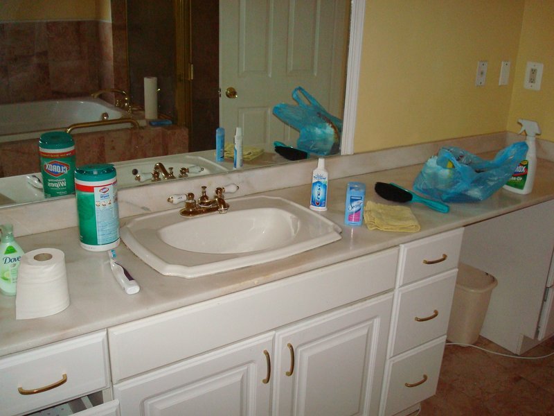 Cluttered bathroom vanity countertop that needs decluttering