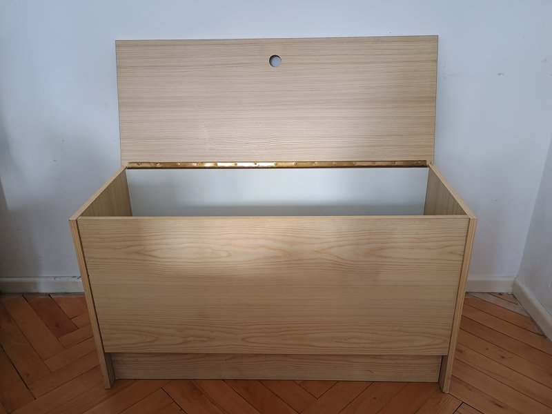 Storage bench with lift-up seat providing hidden storage at the foot of a bed