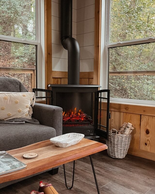 Cozy cabin corner with black wood stove, armchair and wooden coffee table