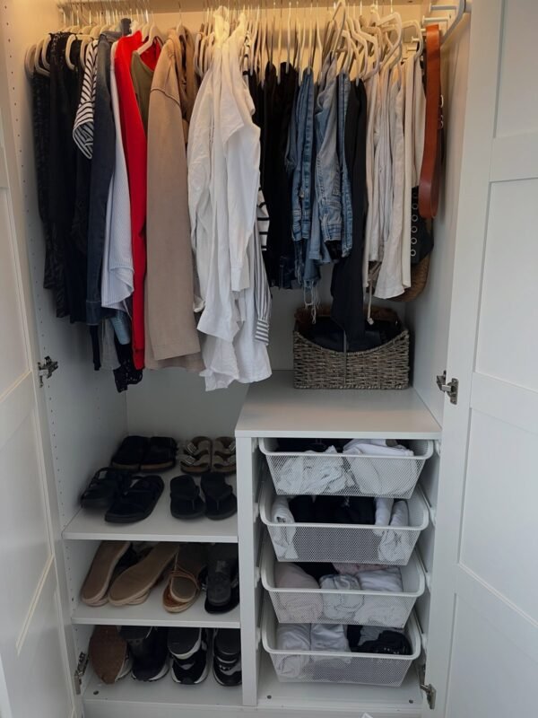 Organized purged wardrobe with neatly hung clothes after decluttering
