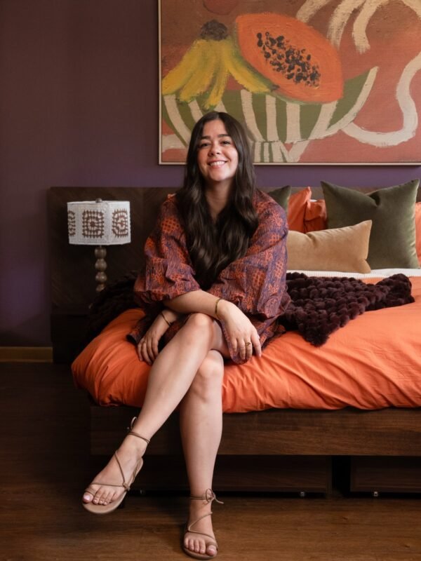 Styled small bedroom makeover with orange bedding and purple walls