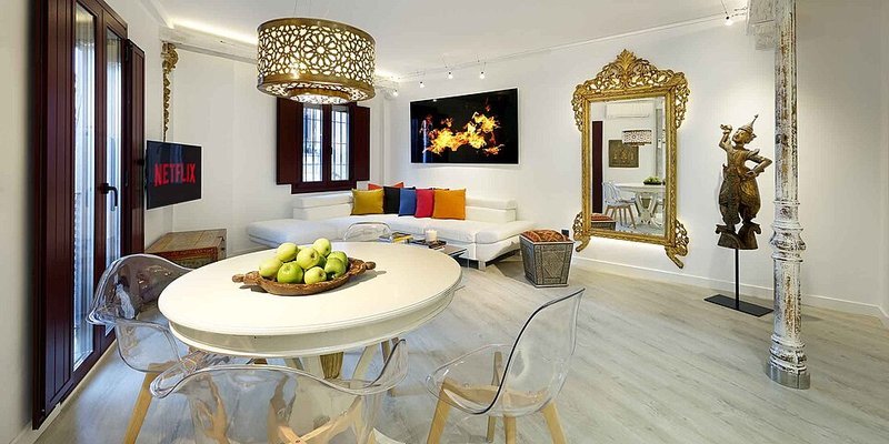 White living room with colorful cushions bringing color back to light walls