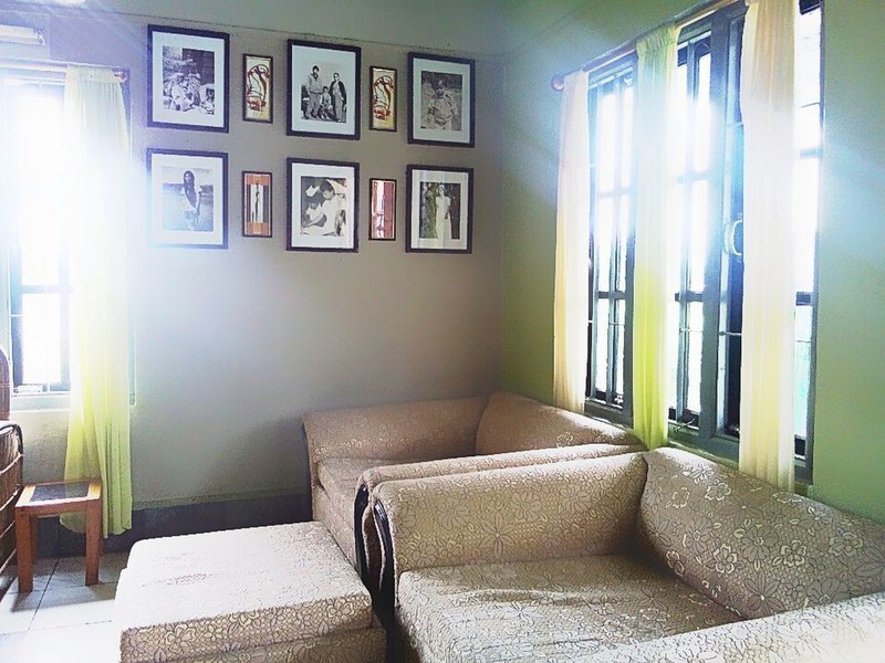 Gallery wall of framed photos arranged above a sofa in a small living room