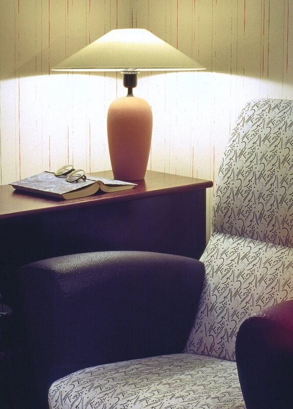 Cozy reading corner with a patterned armchair table lamp and open book